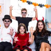 Familia con disfraces caseros celebrando Halloween en casa, disfrutando una fiesta familiar