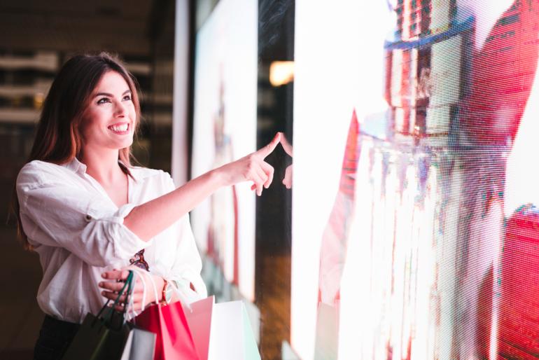 Mujer sonriente de compras en una tienda de decoración comercial futurista.