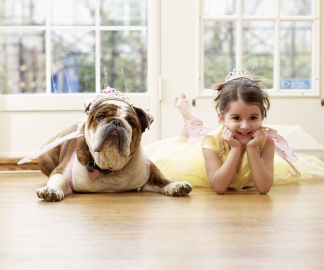 Cuidar tu casa haciendo que todos sean parte, perro y niña disfrazados en el suelo.