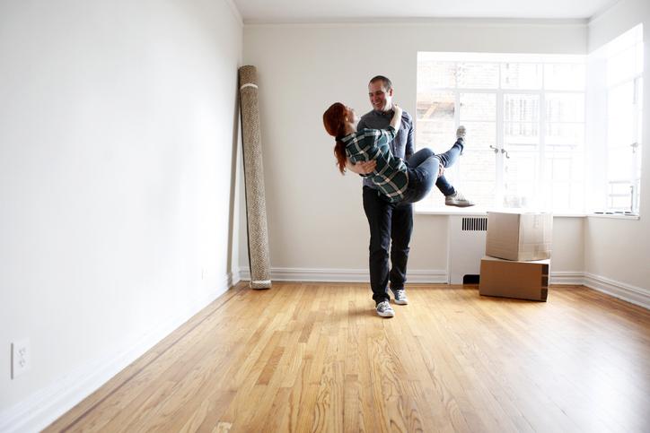 Hombre cargando a su pareja en la sala de su nueva vivienda en El Salitre.