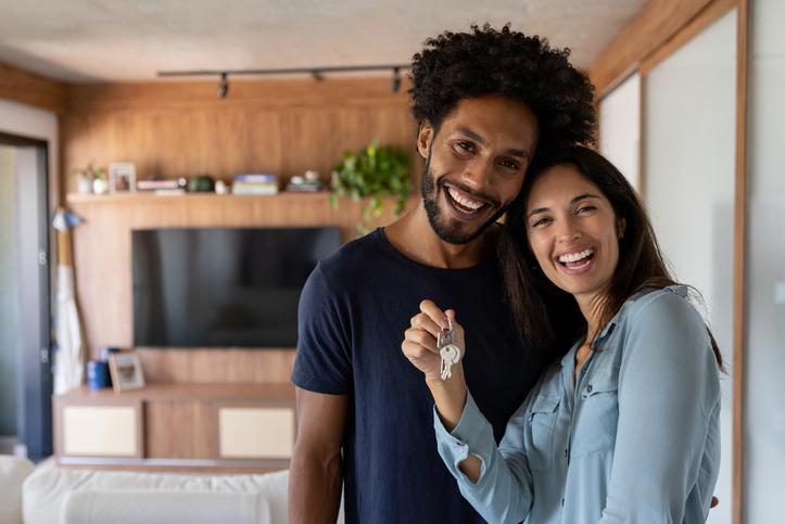  pareja de esposo y esposa sosteniendo las llaves de su casa después de la compra de vivienda nueva.