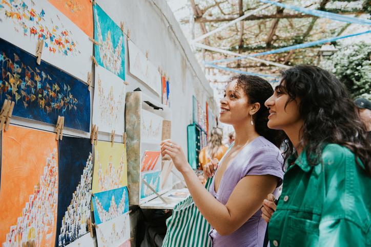 Fotografía de referencia de dos mujeres observando pinturas.