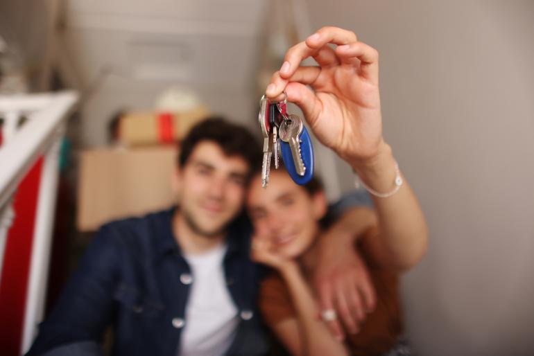 Una pareja sostiene las llaves de su casa, adquirida gracias a proyectos VIS en Bogotá.