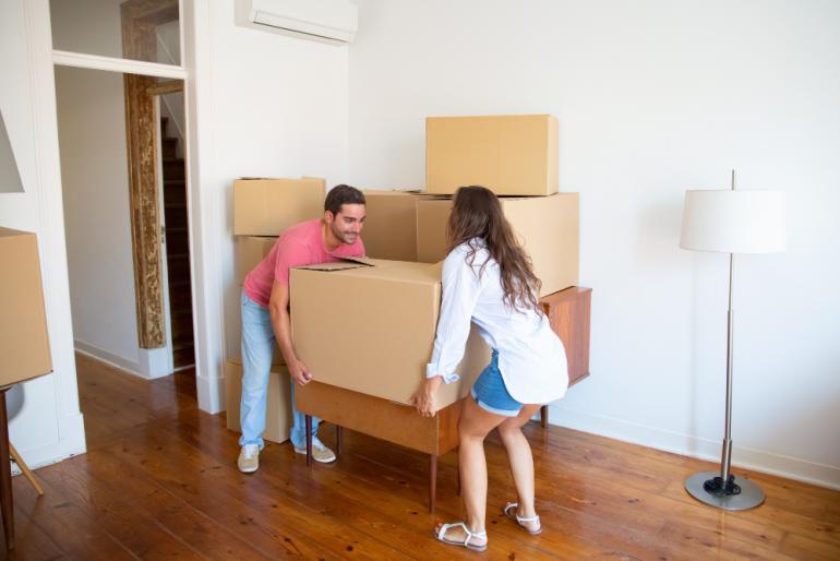 pareja organizando cajas para ahorrar dinero en una mudanza