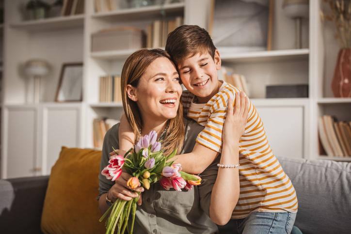 niño entregando carta que hizo con ideas para celebrar el Día de la Madre en casa