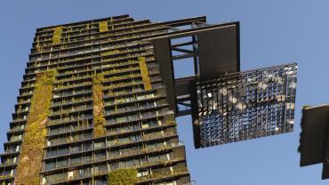 Edificio residencial en Sidney destacando el diseño de edificios resilientes con jardines verticales y helióstato en voladizo. 