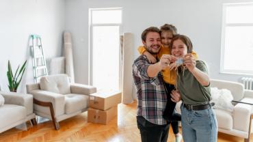 Familia posando feliz con las llaves de su apartamento gracias al subsidio de vivienda Mi Casa Ya.