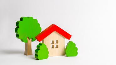  Comprar vivienda en Bogotá con subsidio de oferta preferente. Imagen de referencia con casa de madera pequeña y árboles alrededor.