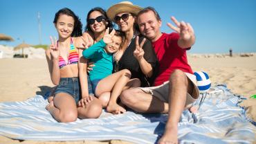  fFamilia disfrutando en la playa por aplicar tips para cuidar la casa en vacaciones