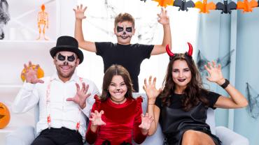 Familia con disfraces caseros celebrando Halloween en casa, disfrutando una fiesta familiar