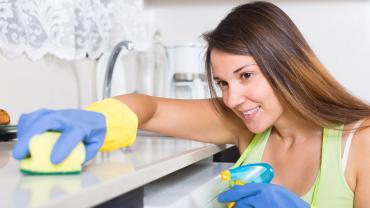 mujer joven haciendo limpieza profunda para fin de año en su apartamento