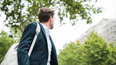 hombre caminando feliz por vivir cerca del trabajo