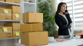 mujer-hablando-por-celular-con-cajas-en-el-escritorio