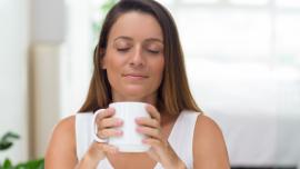 Mujer con los ojos cerrados sintiendo la energía positiva en su casa.