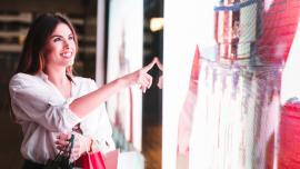 Mujer sonriente de compras en una tienda de decoración comercial futurista.