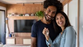  pareja de esposo y esposa sosteniendo las llaves de su casa después de la compra de vivienda nueva.