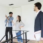 Agente inmobiliario ayudando a buscar la casa en arriendo ideal a una joven pareja.