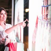 Mujer sonriente de compras en una tienda de decoración comercial futurista.