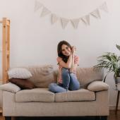 Mujer en casa con decoración acogedora.