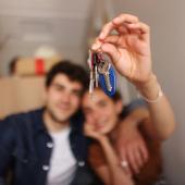 Una pareja sostiene las llaves de su casa, adquirida gracias a proyectos VIS en Bogotá.