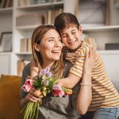 niño entregando carta que hizo con ideas para celebrar el Día de la Madre en casa