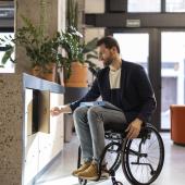  Hombre en silla de ruedas usando rampa con diseño arquitectónico para personas con movilidad reducida
